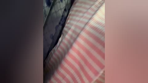 Media: Video of a close-up view of a person's torso with a striped shirt, showcasing alternating pink and white stripes, and a patterned tie with blue and white floral designs.