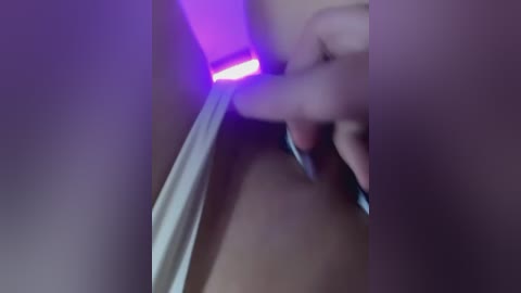 Media: A blurred, close-up video of a hand holding a knife with a glowing purple light, set against a dark background, creating a dramatic, mysterious atmosphere.