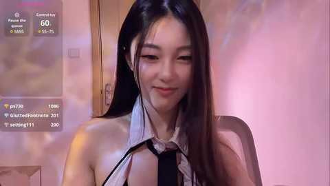 Media: Video of an East Asian woman with long black hair, wearing a white shirt and black tie, sitting indoors, with virtual chat features overlaid.