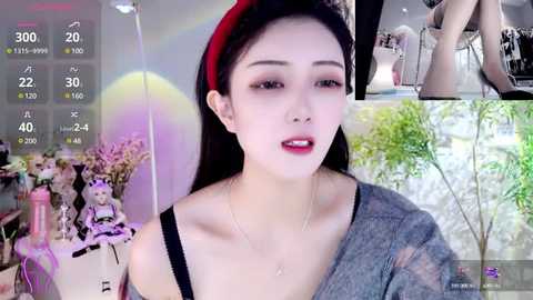 Media: A video collage features a young East Asian woman with fair skin and long black hair, wearing a red beret and a gray sweater, standing in a bright, modern indoor space.