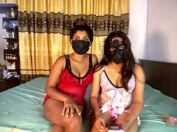 Media: Video of two South Asian women in matching red and black lingerie, face masks, sitting on a bed with green sheets.