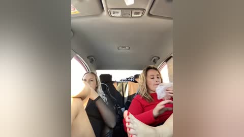 Media: Video of a crowded, dimly lit minivan interior with three women; one wearing a red sweater, another a black top, and a third with a white cloth over her face.