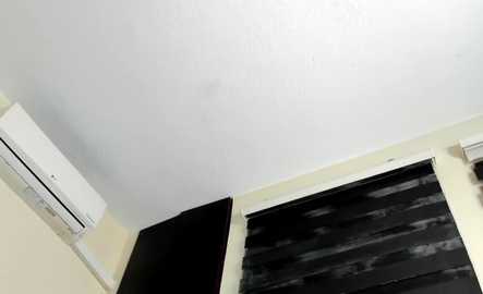 Media: Video of a ceiling with an air conditioning unit on the left, a white wall on the right, and a window with a black and white striped Roman shade.