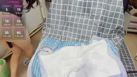 Media: Video of a hospital bed with a patient wearing a blue and white checkered gown, surrounded by medical equipment and a partially visible IV drip.