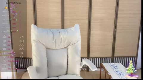 Media: Video of a modern, beige leather recliner chair in a minimalist living room with wooden blinds, a small side table, and a decorative green plant.