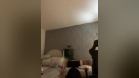 Media: A blurry video of a dimly-lit bedroom with a bed, green lamp, and a dark figure standing near a wall.