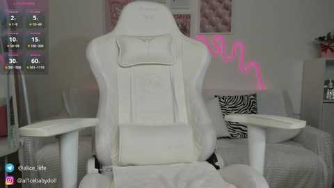 Media: Video of a white gaming chair with a pink neon sign and zebra-print pillow in a minimalistic bedroom.