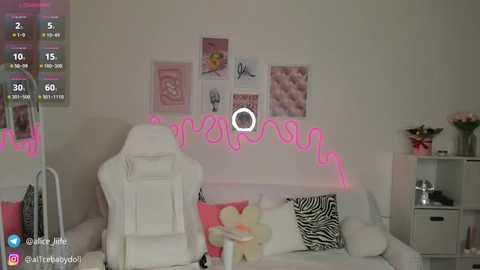 Media: Video of a cozy bedroom with white furniture, a pink neon sign, zebra-print pillows, and a zebra rug, featuring a bright and cheerful decor.