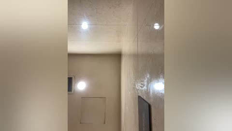 Media: A video of a minimalist hallway with beige walls, featuring recessed lighting and a door on the right. The lighting casts soft shadows, creating a serene ambiance.