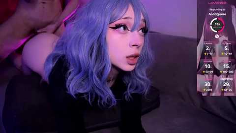 Media: Video of a pale-skinned, blue-haired woman with dramatic makeup, wearing a black top, being sexually penetrated by a person not visible.