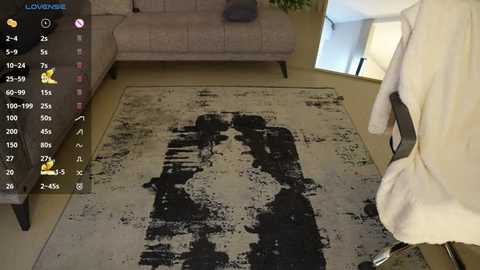 Media: Video of a living room with a beige couch, white carpet with a black handprint, and a person wearing a white bathrobe standing in the background.