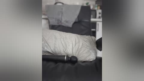 Media: A video of a person lying on a massage table, with a black massage wand on the pillow. The background shows a dimly lit, cozy home setting with a gray blanket and white walls.