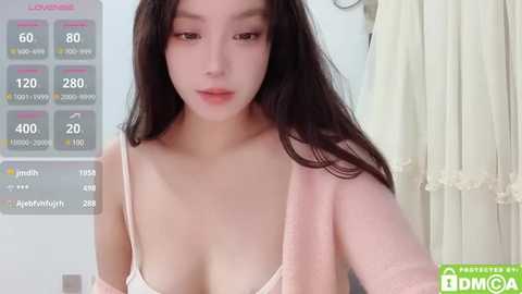 Media: Video of an East Asian woman with long black hair, wearing a pink spaghetti-strap top, in a bathroom with a digital fitness tracker displaying her stats.