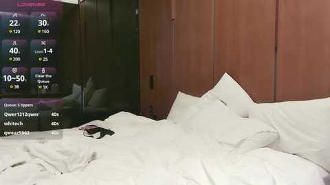 Media: Video of a neatly made bed with white sheets and pillows in a modern, minimalist bedroom. A digital clock displaying 22:12 is visible on a wooden nightstand.