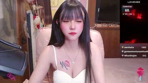 Media: A video of an Asian woman with long black hair, red lipstick, and a white spaghetti strap top, leaning forward with closed eyes and a serene expression.