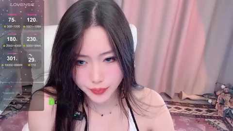 Media: A video of an East Asian woman with long, straight black hair, fair skin, and red lipstick, wearing a white top, against a pink curtain backdrop. She appears in a livestream environment with virtual camera settings displayed.