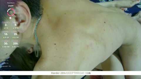 Media: Video of a shirtless man with a silver chain necklace lying on his back, showing multiple red spots and marks on his chest and back, taken in 2018.