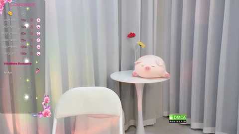 Video of a white chair, a small table, and a pink Kirby plush toy, surrounded by light gray curtains, with a virtual reality headset overlay.