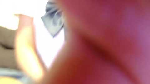 Media: A blurred, close-up video of a person's upper body, possibly a woman, with pinkish skin tone, wearing a blue-striped shirt. The image is out of focus, making it difficult to discern details clearly.