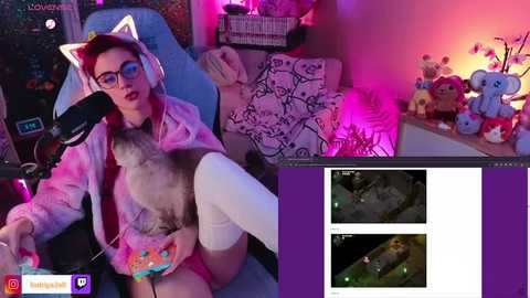 Media: Video of a woman in a cat onesie playing video games on Twitch, surrounded by plush toys and neon lights, showcasing her playful, cozy bedroom setup.