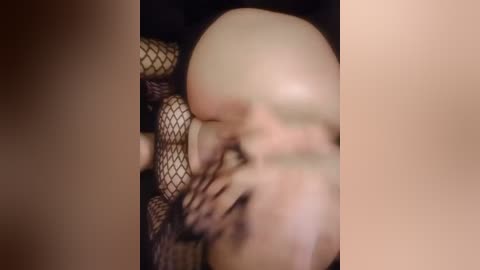 Media: A blurred video of a person wearing black fishnet stockings, with a close-up focus on their exposed buttocks and thighs. The background is dark, making the stockings stand out. The image is grainy and slightly out of focus.