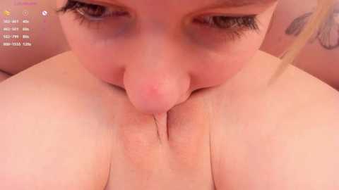 Media: A close-up video of a woman with pale skin, light brown hair, and blue eyes, performing oral sex on a male with a circumcised penis. The background is blurred, focusing on the intimate act.