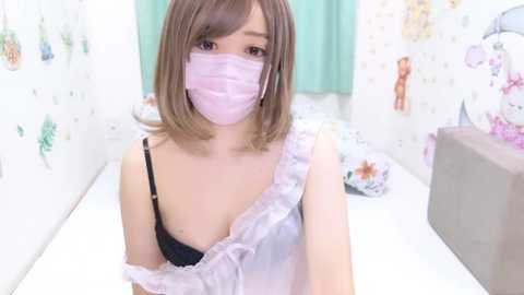 Media: Video of a young Asian woman with light skin and shoulder-length brown hair, wearing a pink face mask and a lacy white top exposing her black bra. She's in a pastel-colored, floral-themed bathroom.