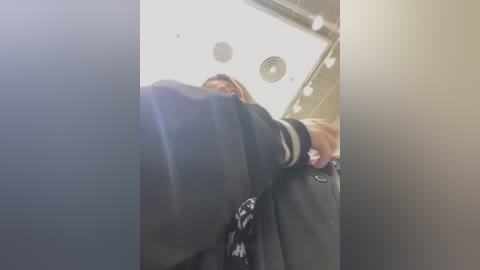 Media: A video of a person in a black jacket, possibly a security guard, seen from a low angle, with a blurred background.