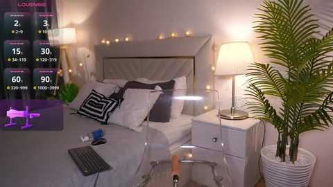 Media: Video of a modern, cozy bedroom with a white bed, white nightstands, a potted plant, and fairy lights.