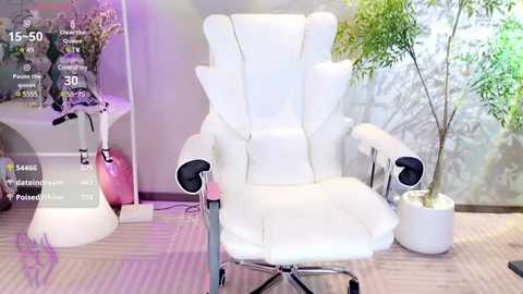 Media: A video of a sleek, white ergonomic office chair with a tall backrest, placed in a modern, minimalist room with a striped carpet, a potted plant, and a white side table.