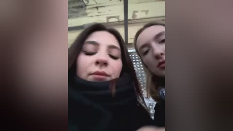 Media: Video of two women with closed eyes in a train, possibly asleep; one has long dark hair, the other blonde.