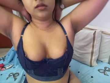 Media: Video of a light-skinned woman with medium-sized breasts, wearing a navy blue lace bra and black thong, lying on a light blue bed with butterfly pattern.