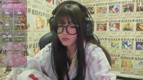 Media: Video of a young Asian woman with long black hair, wearing glasses, headphones, and a white floral shirt, sitting in a chair surrounded by newspaper clippings.