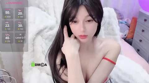 Media: A video of an East Asian woman with long, straight black hair and fair skin, wearing a red strapless dress, lying on a white bed, with a green \"DIYA\" watermark and a temperature gauge overlay.