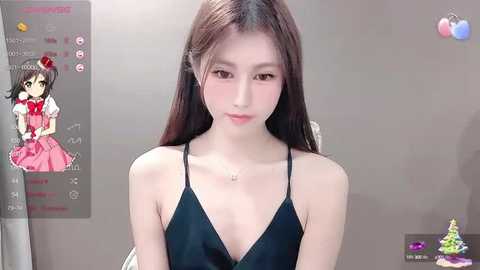 Media: Video of a young East Asian woman with long brown hair, fair skin, and small breasts, wearing a black spaghetti strap top, against a plain beige wall.