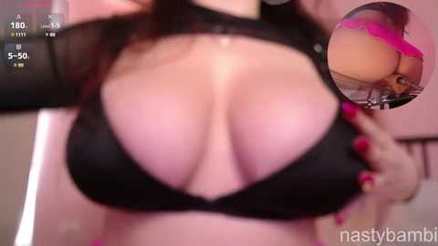 Media: Video of a woman with large breasts wearing a black, sheer top that reveals cleavage, taken from a first-person perspective. A side inset shows her wearing pink lingerie.