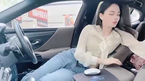 Media: Video of an Asian woman with long black hair, wearing a beige blouse and jeans, asleep in a car with a laptop on her lap, and a white mouse on the dashboard.