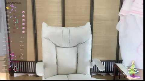 Media: A video shows a white leather recliner chair in a modern room with beige walls and wooden blinds. The background includes a pink teddy bear and a small tree.