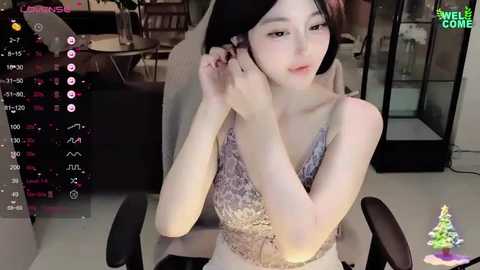 Media: Video of an East Asian woman with pale skin, black hair, and small breasts, wearing a patterned sleeveless top, adjusting her hair in a modern office setting.