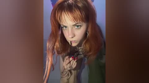 Media: Video of a fair-skinned woman with long, wavy red hair and blue eyes, wearing glasses, holding them close to her face, in a dimly lit room.