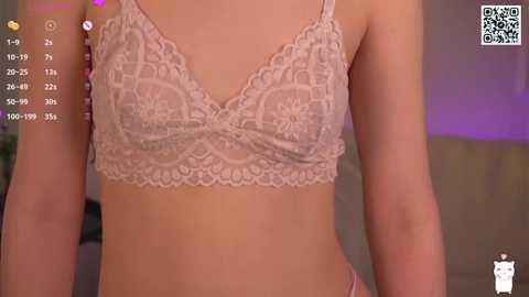 Media: Video of a slender, light-skinned woman in a pink lace bralette, with a blurred background.