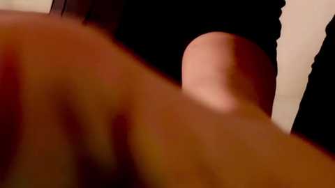 Media: Video of a close-up, blurred view of a person's lower back, showing skin tone and a black garment, suggesting an intimate, possibly sexual context.