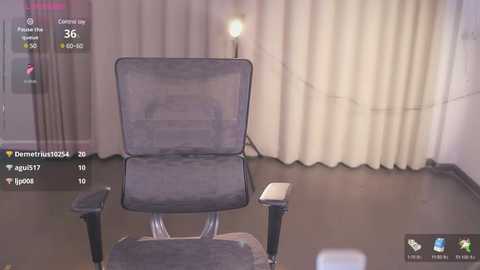 Media: Video of a dimly lit room with a gray mesh office chair facing a beige curtain. A smartphone with an AR app displays a digital overlay of a user's avatar, suggesting a mixed reality setting.