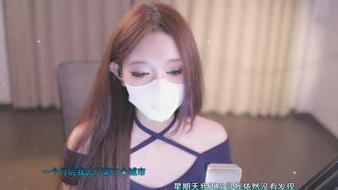 Media: Video of an Asian woman with long brown hair, wearing a white face mask, off-shoulder black top, and sitting at a table in a dimly lit room. Text overlays in Chinese characters.