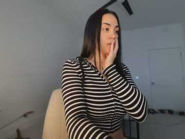 Media: A video of a young woman with long black hair, wearing a black-and-white striped hoodie, sitting on a beige chair, with a surprised expression, in a modern, minimalist room.