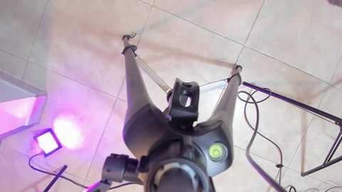 Media: Video of a black telescope mounted on a tripod, set up on a tiled floor with fluorescent lighting and cables visible.