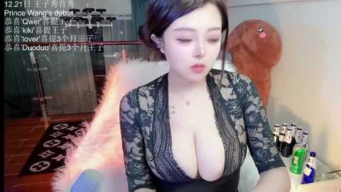 Media: Video of an East Asian woman with short black hair, wearing a revealing black lace top, sitting in a room with a plush toy and drinks.