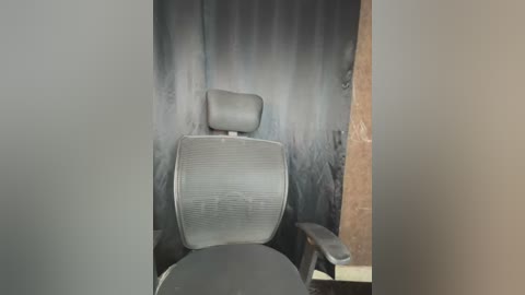 Media: Video of an empty, dimly lit office with a black mesh chair and dark gray wall. The chair's headrest is visible, and the room appears sparse and somewhat neglected.