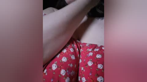 Media: Video of a close-up of a person's torso, showing red pajama pants with white Hello Kitty pattern. The person's arm is bent and partially obscuring the view.