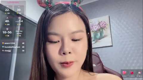 Media: A video of an Asian woman with long dark hair wearing a festive headband, sitting indoors, featuring a live stream interface with social media metrics.